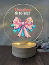 a glass plaque with a pink bow on it