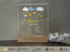 a clear acrylic plaque with stars and clouds