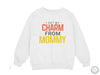 a white sweatshirt that says i get my charm from mommy